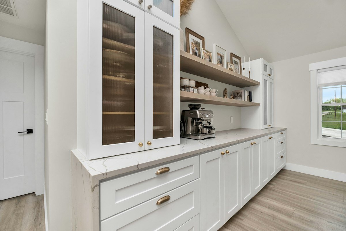 Cocina blanca con muebles altos de puertas de cristal