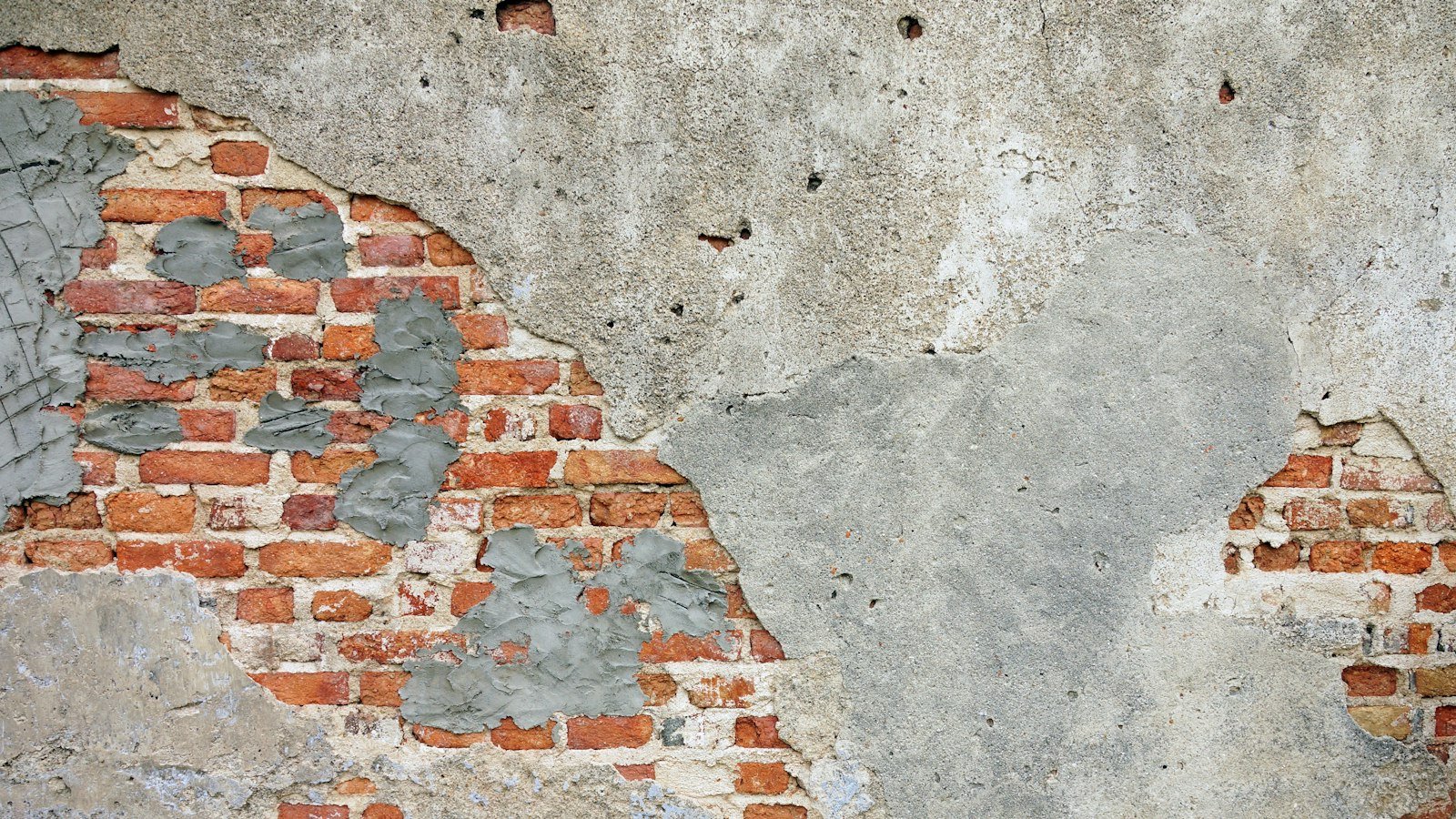 Pared vieja con el yeso caído y el ladrillo a la vista